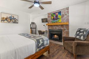 een slaapkamer met een bed en een open haard bij Cabin 17 - King Bed New Kitchen & Bath in Estes Park +19 foto's