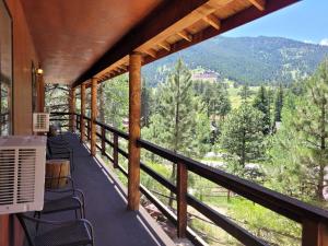 a balcony with chairs and a view of the mountains at Cabin 17 - King Bed New Kitchen & Bath in Estes Park