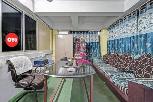 une pièce avec un canapé, une table et des chaises dans l'établissement Hotel O Coastal Inn Luxury Service Apartments, à Kakinada