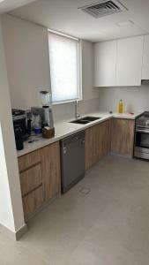 an empty kitchen with wooden cabinets and a sink at Noya Viva villa in Abu Dhabi