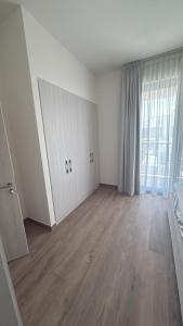 an empty living room with white walls and wood floors at Noya Viva villa in Abu Dhabi