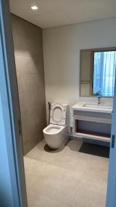 a bathroom with a toilet and a sink and a mirror at Noya Viva villa in Abu Dhabi