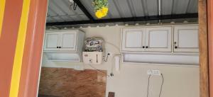 a kitchen with white cabinets and a sink at THE FARM CREST, ECR KADALLUR in Kūvattūr