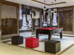 a room with a ping pong table and two stools at ibis Barretos in Barretos