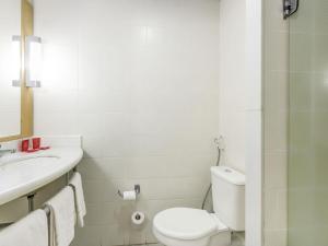 a white bathroom with a toilet and a sink at ibis Barretos in Barretos +77 photos