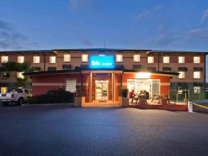 Un edificio con una puerta de autobús enfrente. en ibis Budget Coffs Harbour, en Coffs Harbour