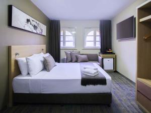 a bedroom with a large bed and a television at ibis Budget - Melbourne CBD in Melbourne