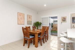 ein Esszimmer mit einem Holztisch und Stühlen in der Unterkunft Executive Townhouse Near Heart of Adelaide City in Rose Park + 14 Fotos