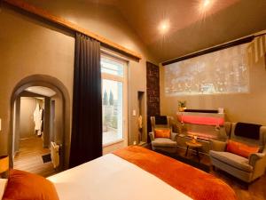 ein Schlafzimmer mit Bett und ein Wohnzimmer in der Unterkunft Suite Phoenix avec Cheminée, Terrasse et Videoprojecteur in Angoulême
