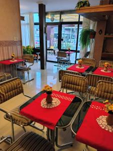 a restaurant with red tables and chairs with red napkins at Hotel Ritz in Villa Carlos Paz