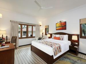 a hotel room with a bed and a desk at Novotel Goa Dona Sylvia Resort in Cavelossim