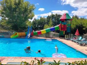 2 personnes dans une piscine avec toboggan dans l'établissement Gîte avec Terrasse et Salon de Jardin - API-1-52-592, à Dévillac