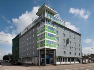 a tall gray building with green windows on a street at ibis Styles Halle in Halle an der Saale