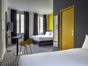 Cette chambre d'hôtel dispose de 2 lits et d'une porte jaune. dans l'établissement ibis Styles Marseille Vieux Port, à Marseille 60 autres photos