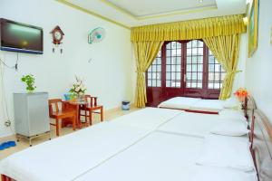 a bedroom with two beds and a tv at Thanh Tùng Hotel in Can Tho