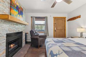 een slaapkamer met een bed en een open haard bij Cabin 19- King Studio Gorgeous views Hotel Style in Estes Park