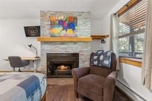 een slaapkamer met een open haard en een bed en een stoel bij Cabin 19- King Studio Gorgeous views Hotel Style in Estes Park