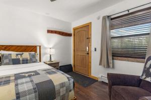a bedroom with a bed and a chair and a window at Cabin 18 - King Bed Mountain views Hotel Style in Estes Park