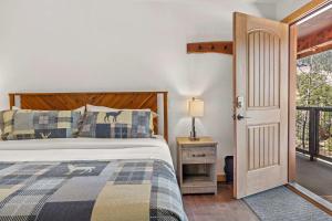 a bedroom with a bed and a door to a balcony at Cabin 18 - King Bed Mountain views Hotel Style in Estes Park