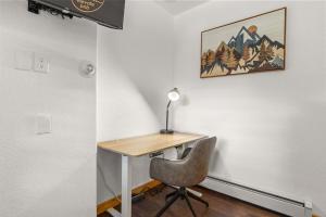una scrivania con sedia e una lampada appesa a un muro di Cabin 18 - King Bed Mountain views Hotel Style a Estes Park Altre 19 foto