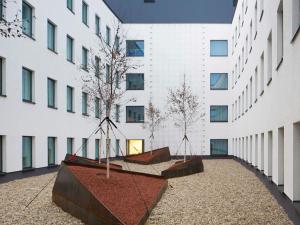 a courtyard in a building with a swing at ibis Styles Budapest Airport in Vecsés