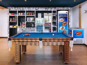 un tavolo da biliardo di fronte a un negozio di ibis budget Barbacena a Barbacena