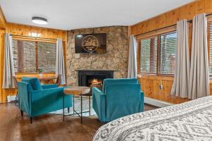 een slaapkamer met twee blauwe stoelen en een open haard bij Cabin 21- Accessible Unit & King Bed in Estes Park