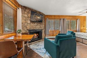 een woonkamer met een open haard en een tafel en stoelen bij Cabin 21- Accessible Unit & King Bed in Estes Park