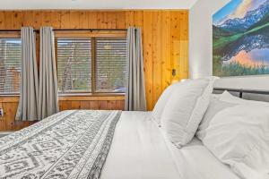 een slaapkamer met een wit bed en 2 ramen bij Cabin 21- Accessible Unit & King Bed in Estes Park
