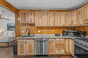 een keuken met houten kasten en een bed in een slaapkamer bij Cabin 21- Accessible Unit & King Bed in Estes Park +20 foto's