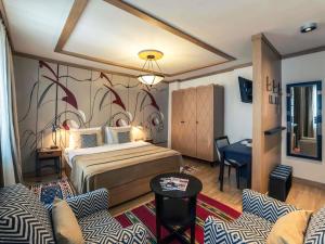 a hotel room with a bed and a table and chairs at Mercure Belgrade Excelsior in Belgrade +130 photos