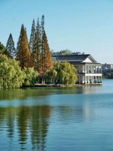 FunGee X Hotel 长沙国金中心南门口地铁站店 في تشانغشا: منزل كبير على شاطئ البحيرة