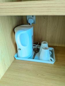 Une cafetière et des tasses se trouvent sur une étagère. dans l'établissement Sky Suite KLCC Apartment klcc, à Gua Sai