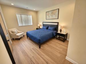 a bedroom with a blue bed and a chair at Urban Chic residence in Central LA in Los Angeles