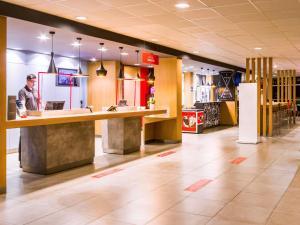 a man standing at a counter in a fast food restaurant at ibis Marilia in Marília