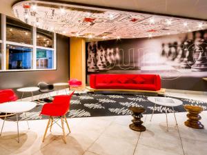 a waiting room with red chairs and a red couch at ibis Marilia in Marília