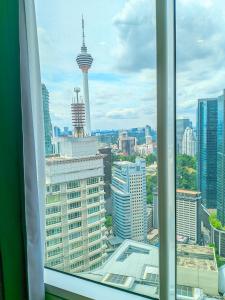 Elle offre une vue sur les toits de la ville depuis sa fenêtre. dans l'établissement Sky Suite KLCC Apartment klcc, à Gua Sai