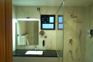 a bathroom with a shower and a sink and a mirror at The Lovedale Kodaikanal Stay & Hotel in Kodaikānāl +72 photos