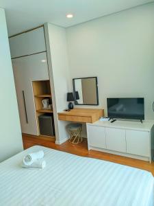 une chambre avec un lit, une télévision et un miroir dans l'établissement Sky Suite KLCC Apartment klcc, à Gua Sai