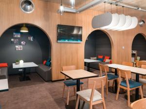 un restaurant avec des tables, des chaises et un canapé dans l'établissement ibis Styles Chalons en Champagne Centre, à Châlons-en-Champagne