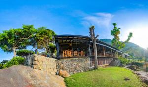 a house on a hill with a stone wall at Melheim Resort and Spa in Haputale