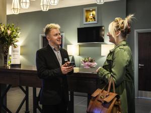a man and a woman talking in a hotel room at Mercure Bridgwater in Bridgwater