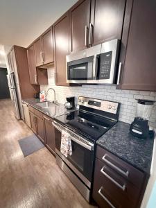 a kitchen with a stove and a microwave at Contemporary Comfort Near The Woodlands in Spring