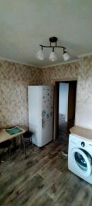 Il comprend une cuisine équipée d'un lave-linge, d'un réfrigérateur et d'une table. dans l'établissement Рахмет, à Petropavlovsk-Kamtchatski