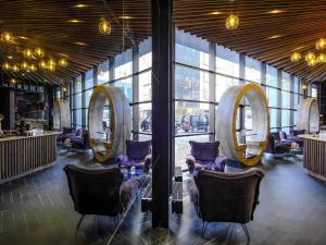 a lobby with chairs and mirrors in a building at Mercure Kyiv Congress in Kyiv