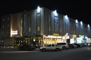 حياة روز للشقق المخدومة في المدينة المنورة: مبنى كبير به سيارات متوقفة في موقف السيارات