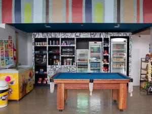 ein Geschäft mit Billardtisch vor einem Geschäft in der Unterkunft ibis budget Muriae in Muriaé
