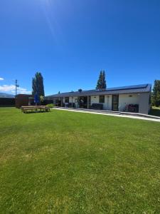 Un edificio con un césped verde delante. en Penny's Drop Inn, en Cromwell