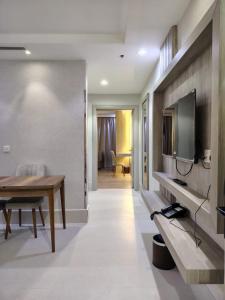 حياة روز للشقق المخدومة في المدينة المنورة: غرفة معيشة مع طاولة وتلفزيون على الحائط