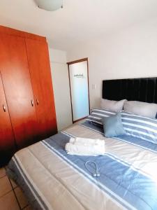 a bedroom with a large bed with a wooden headboard at Luxury Living in Jbay in Jeffreys Bay